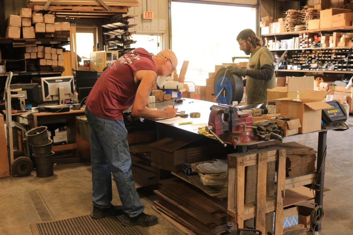 Seal Rite crew working inside the factory in Auxvasse, MO. Seal Rite employees busy working on various tasks inside the factory, including fabricating parts and assembling equipment for asphalt and seal coating.