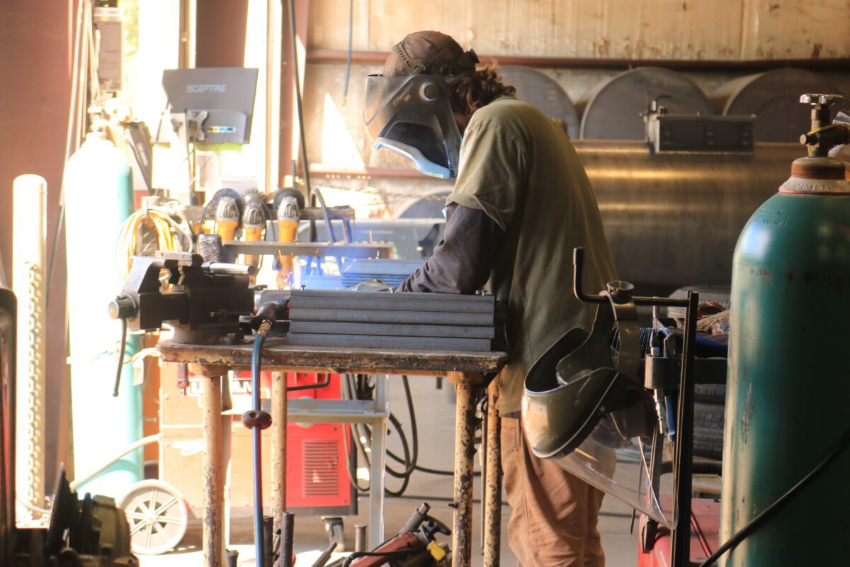 A welder at Seal Rite in Auxvasse, MO, working on fabricating components for seal coating equipment, demonstrating the hands-on craftsmanship at the facility.