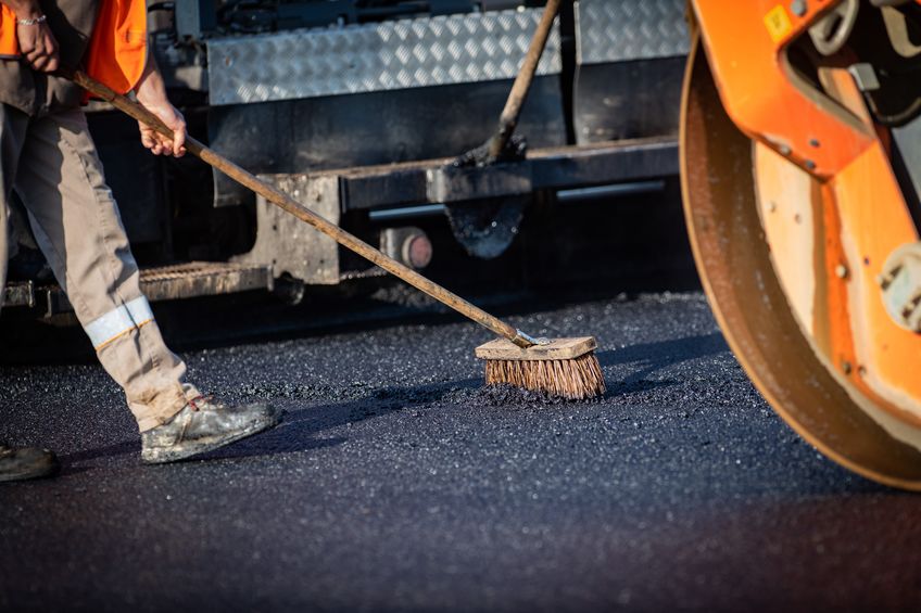 sealcoating company doing sealcoating job on road